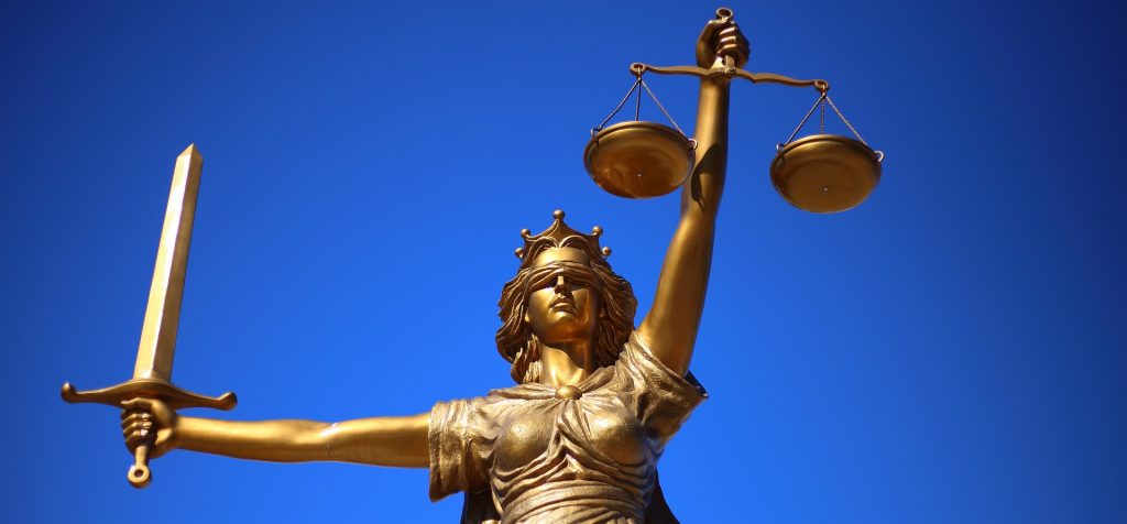 Statue of Lady Justice against a blue sky background